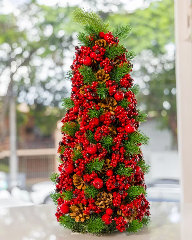 Árvore de Natal decorada com pinhas e cerejas vermelhas